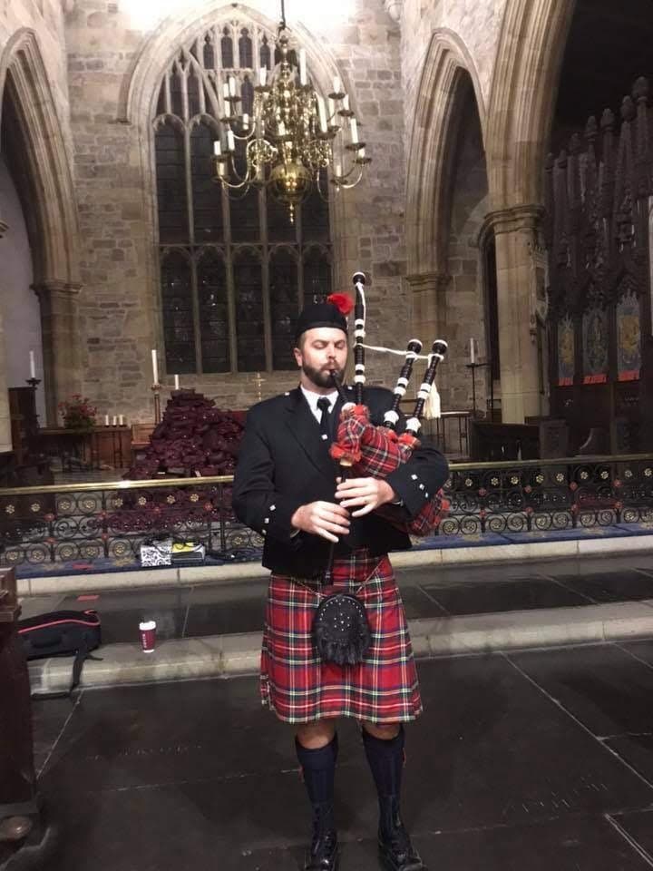 Ryan playing bagpipes inside a church